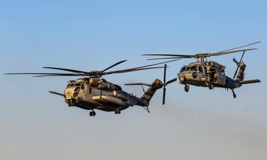 A U.S. Marine Corps CH-53E Super Stallion with Marine Medium Tiltrotor Squadron (VMM) 162, 26th Marine Expeditionary Unit and a U.S. Navy MH-60S Seahawk with Helicopter Sea Combat Squadron (HSC) 28 , conduct a flyby of the Wasp-class amphibious assault ship USS Iwo Jima (LHD07), May 13, 2018